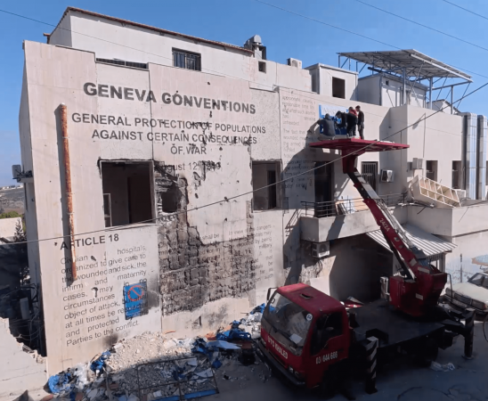 Lebanese muralist and calligrapher Ghaleb Hawila meticulously inscribed articles from the Geneva Convention onto the building’s shattered walls.