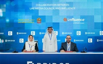 From left, Maitha Al Suwaidi, CEO of Strategy and Media Policies Sector, UAE Media Council; Mohammed Saeed Al Shehhi, Secretary-General of the UAE Media Council (standing); and Mike Alnaji, CEO, Imfluence. ink an MoU for the Visitors Advertiser Permit