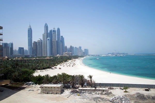 Skyscrapers sit at Dubai Marina, left, on the city skyline beyond the beach and coastline in Dubai, United Arab Emirates, on Sunday, May 8, 2016. Dubai's housing market, the biggest and most volatile in the Middle East, is in the doldrums as falling oil prices, a weaker euro and ruble and an abundance of properties damp demand. Photographer: Razan Alzayani/Bloomberg via Getty Images